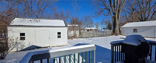 snow covered property with an outbuilding