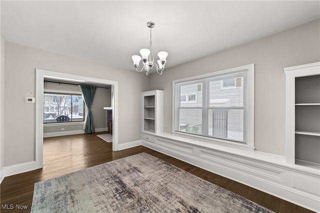 unfurnished dining area featuring dark wood-type flooring and a chandelier