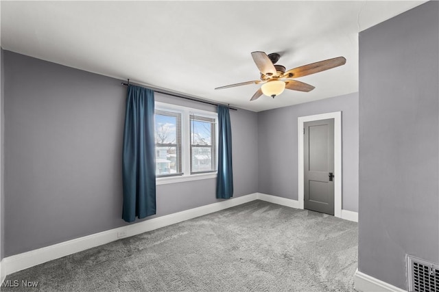 carpeted spare room featuring ceiling fan