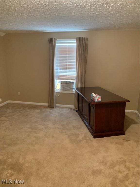 unfurnished office with a textured ceiling, light colored carpet, and cooling unit