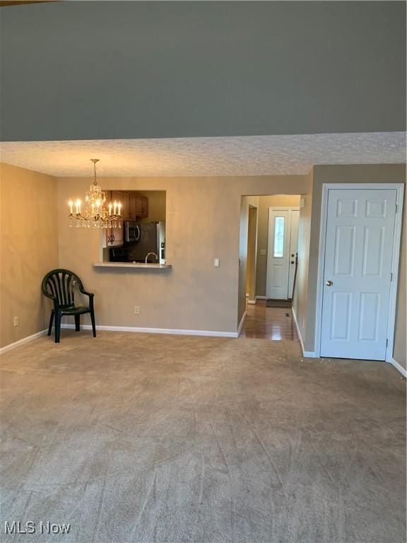 unfurnished room with carpet floors and a notable chandelier