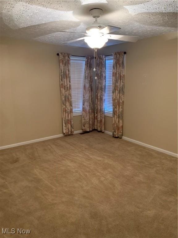 carpeted spare room featuring ceiling fan and a textured ceiling