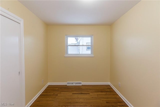 spare room featuring dark wood-type flooring