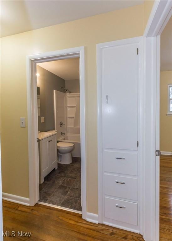 full bathroom featuring shower / tub combination, hardwood / wood-style floors, vanity, and toilet