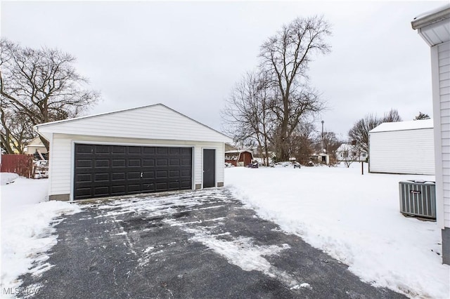 snow covered garage featuring central AC