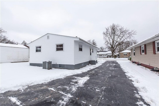 view of snow covered exterior featuring central AC unit