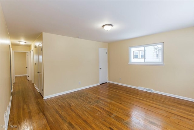 empty room with dark hardwood / wood-style flooring