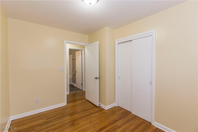 unfurnished bedroom with hardwood / wood-style floors and a closet