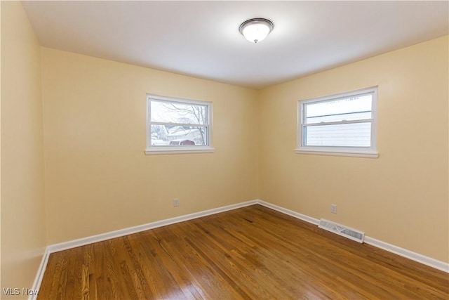 unfurnished room with hardwood / wood-style flooring