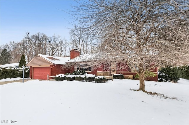 view of snowy exterior featuring a garage