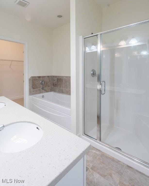 bathroom featuring visible vents, a garden tub, a stall shower, and vanity
