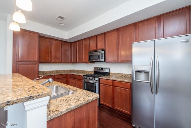 kitchen with pendant lighting, dark wood finished floors, visible vents, appliances with stainless steel finishes, and a sink