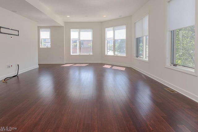 unfurnished room featuring baseboards, recessed lighting, and dark wood finished floors