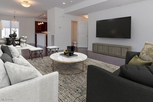 living area featuring baseboards, recessed lighting, and wood finished floors