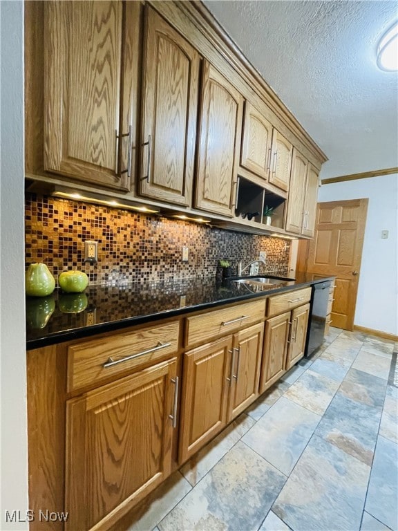 kitchen with decorative backsplash, dark stone counters, a textured ceiling, sink, and black dishwasher