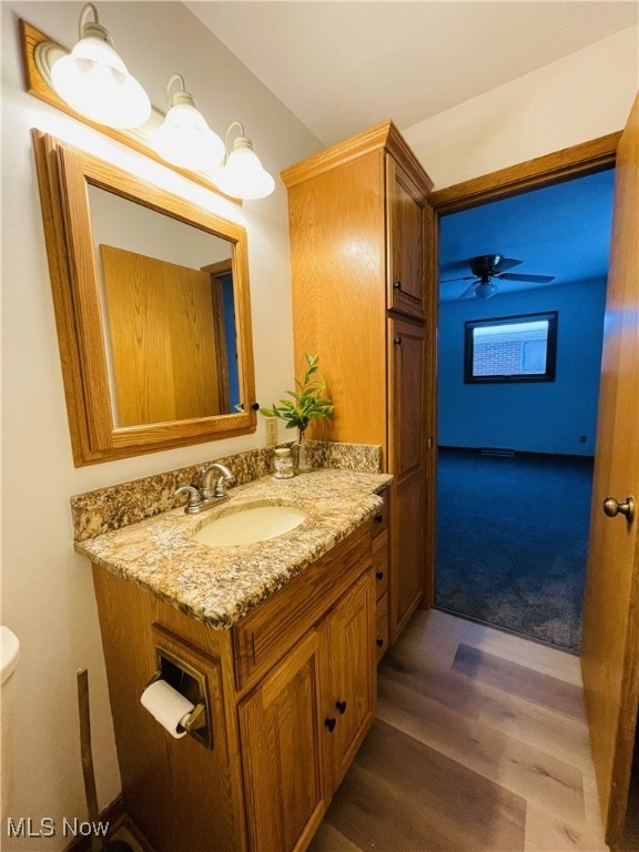 bathroom with vanity, ceiling fan, toilet, and wood-type flooring