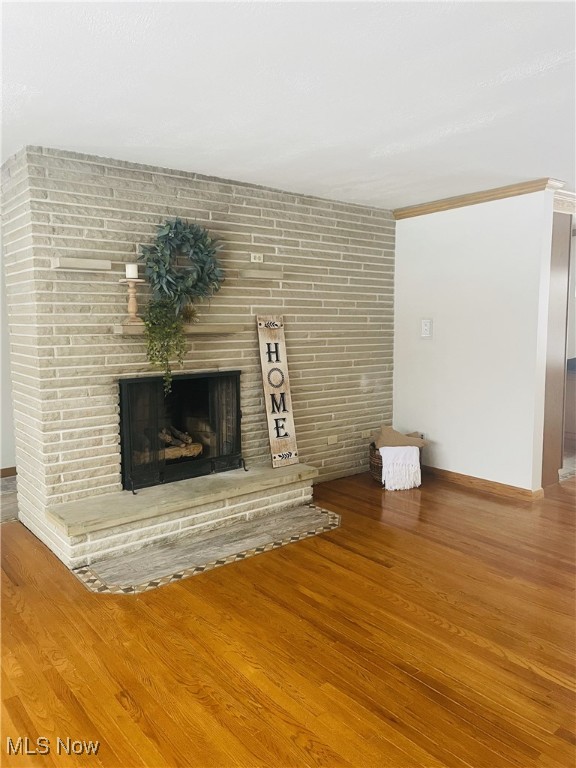 unfurnished living room with a fireplace and hardwood / wood-style flooring