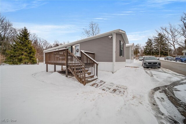 view of snowy exterior featuring a deck