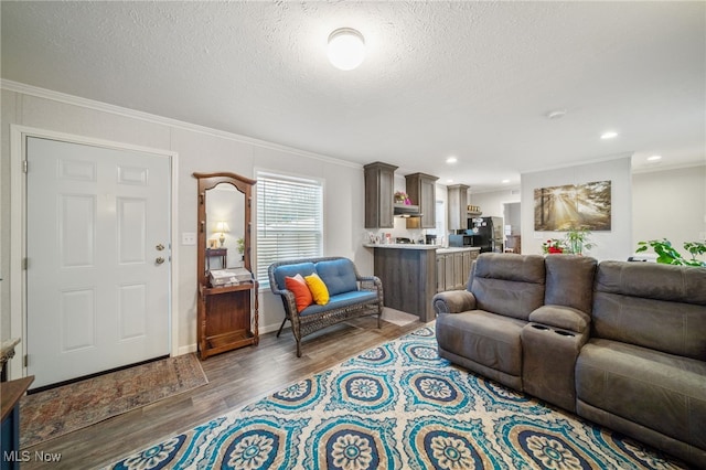 living room featuring a textured ceiling, wood finished floors, and crown molding