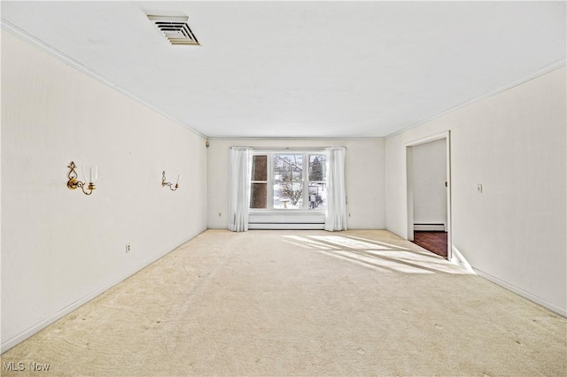 carpeted empty room with baseboard heating, crown molding, and baseboards