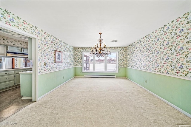 unfurnished dining area featuring a baseboard heating unit, an inviting chandelier, and light colored carpet