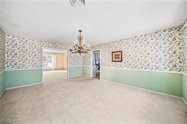 unfurnished room with carpet and a notable chandelier