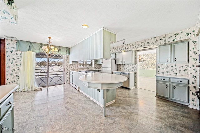 kitchen featuring pendant lighting, a textured ceiling, white fridge, and an inviting chandelier