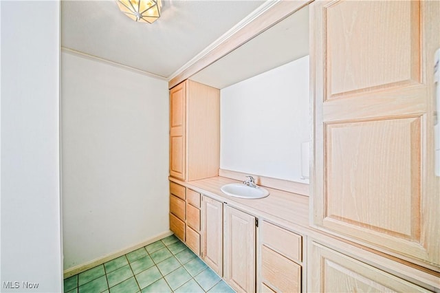 bathroom with tile patterned flooring, crown molding, and vanity