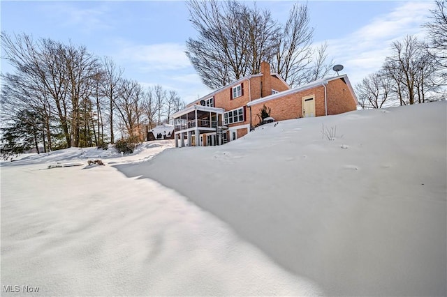 snow covered house with a sunroom