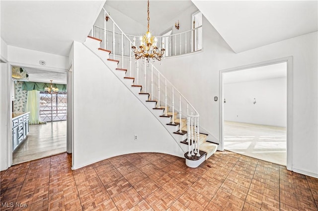 stairway featuring a chandelier and a towering ceiling