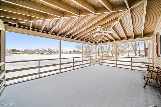 unfurnished sunroom featuring ceiling fan, wooden ceiling, and beamed ceiling