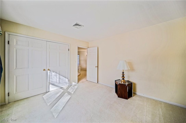unfurnished bedroom with carpet floors, a closet, and baseboards