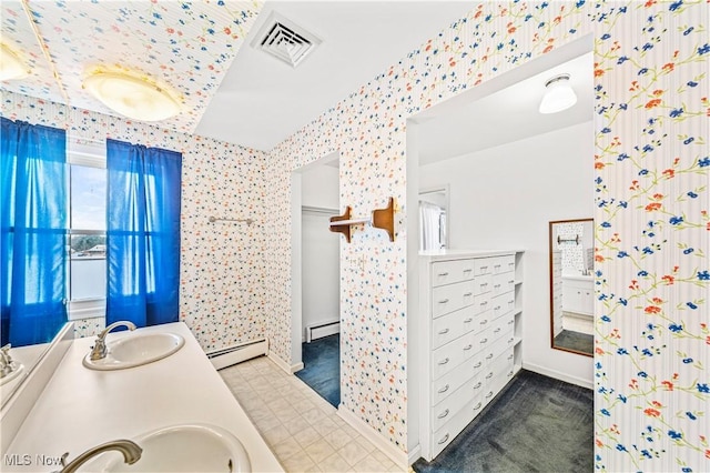 full bath with baseboard heating, double vanity, baseboards, and wallpapered walls