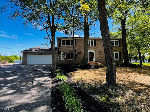view of front of home with brick siding, a garage, and driveway