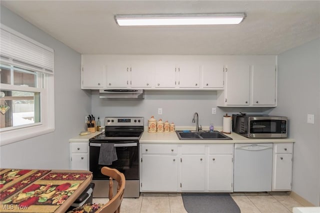 kitchen with sink, white cabinets, light tile patterned flooring, and appliances with stainless steel finishes