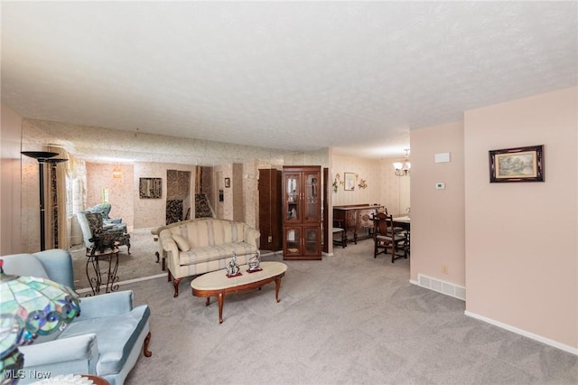 carpeted living room with a chandelier and a textured ceiling