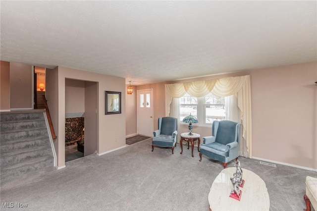 living area with carpet flooring and a textured ceiling