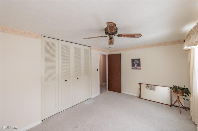 unfurnished bedroom with light carpet, a closet, and ceiling fan