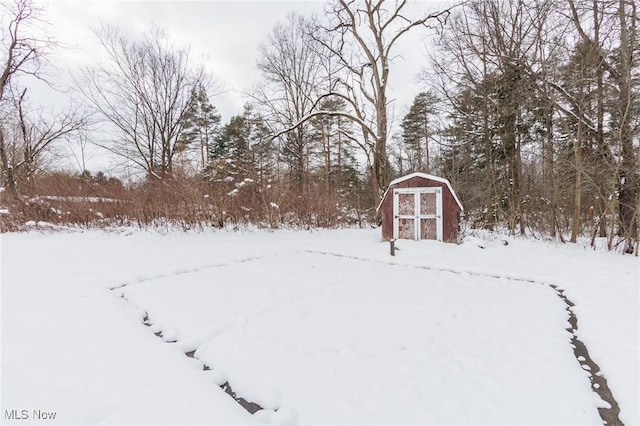 yard covered in snow featuring a storage shed