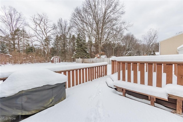 snow covered deck with a shed