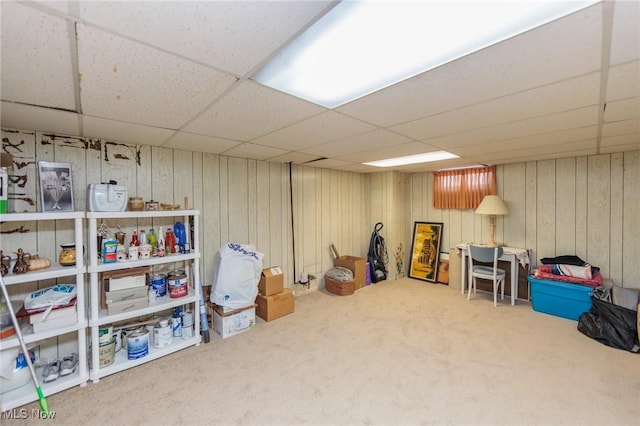 basement with a paneled ceiling and carpet