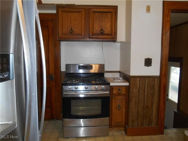 kitchen with wood walls and appliances with stainless steel finishes