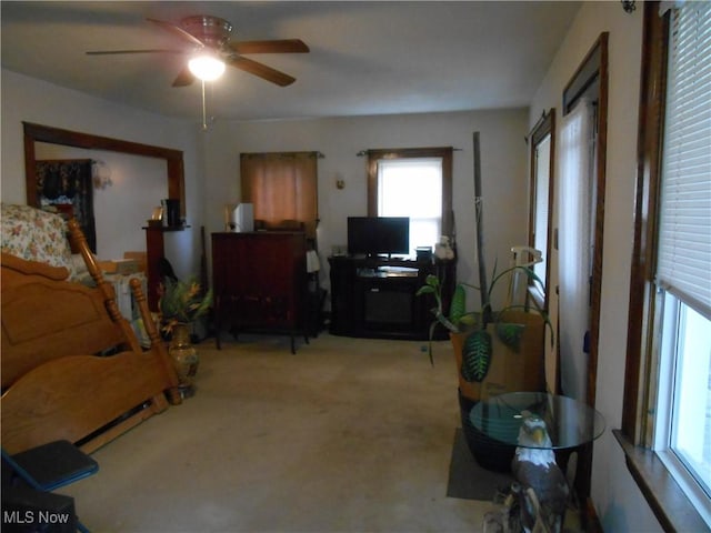 interior space featuring light carpet and ceiling fan