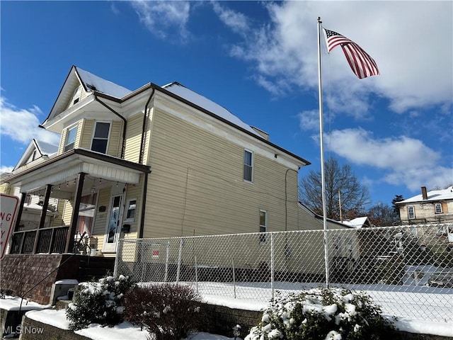 snow covered property with a porch