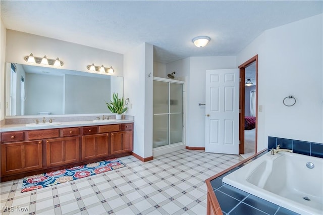 bathroom featuring shower with separate bathtub, vanity, and a textured ceiling