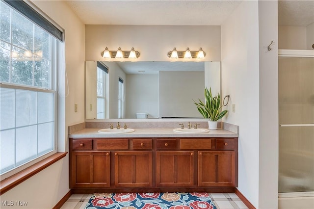 bathroom with vanity, toilet, and a shower with door