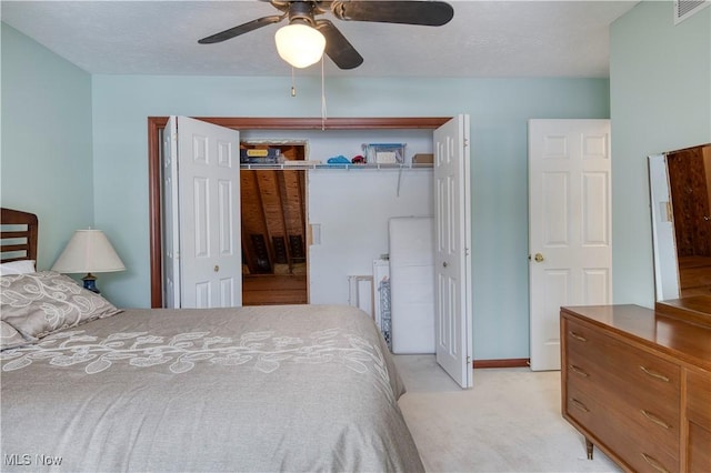 bedroom with a textured ceiling, ceiling fan, light carpet, and a closet