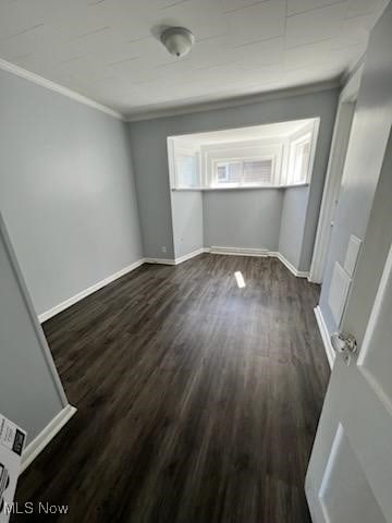 spare room featuring ornamental molding and dark hardwood / wood-style floors