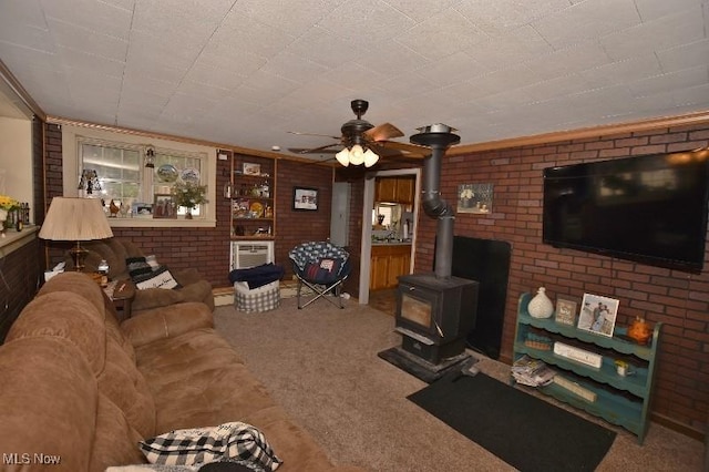 living room featuring carpet, a wall mounted air conditioner, a wood stove, ceiling fan, and brick wall