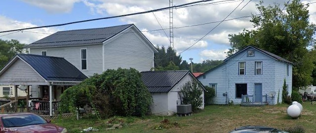 exterior space with central AC unit, a porch, and a front lawn